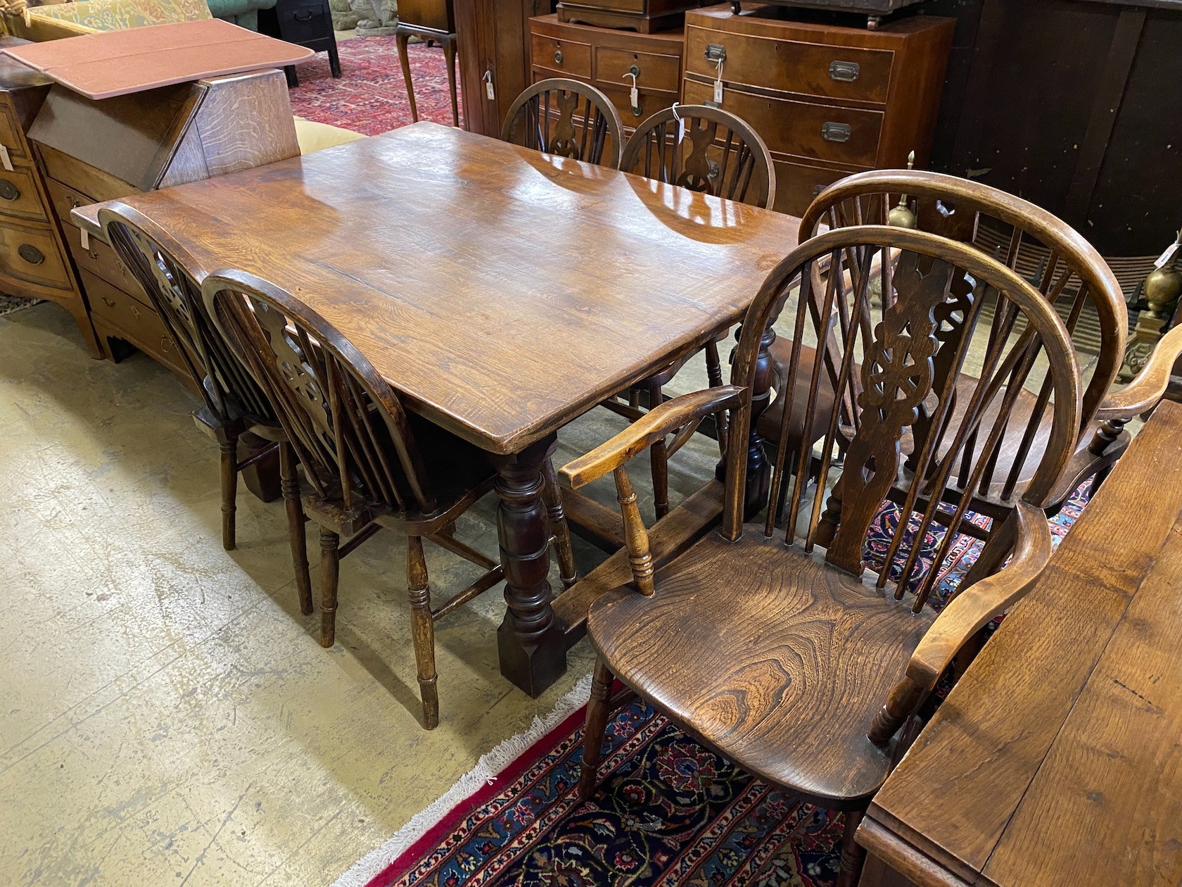 A small 18th century style rectangular oak refectory dining table, length 137cm, width 98cm, height 75cm and a harlequin set of six elm and beech Windsor wheelback dining chairs, two with arms